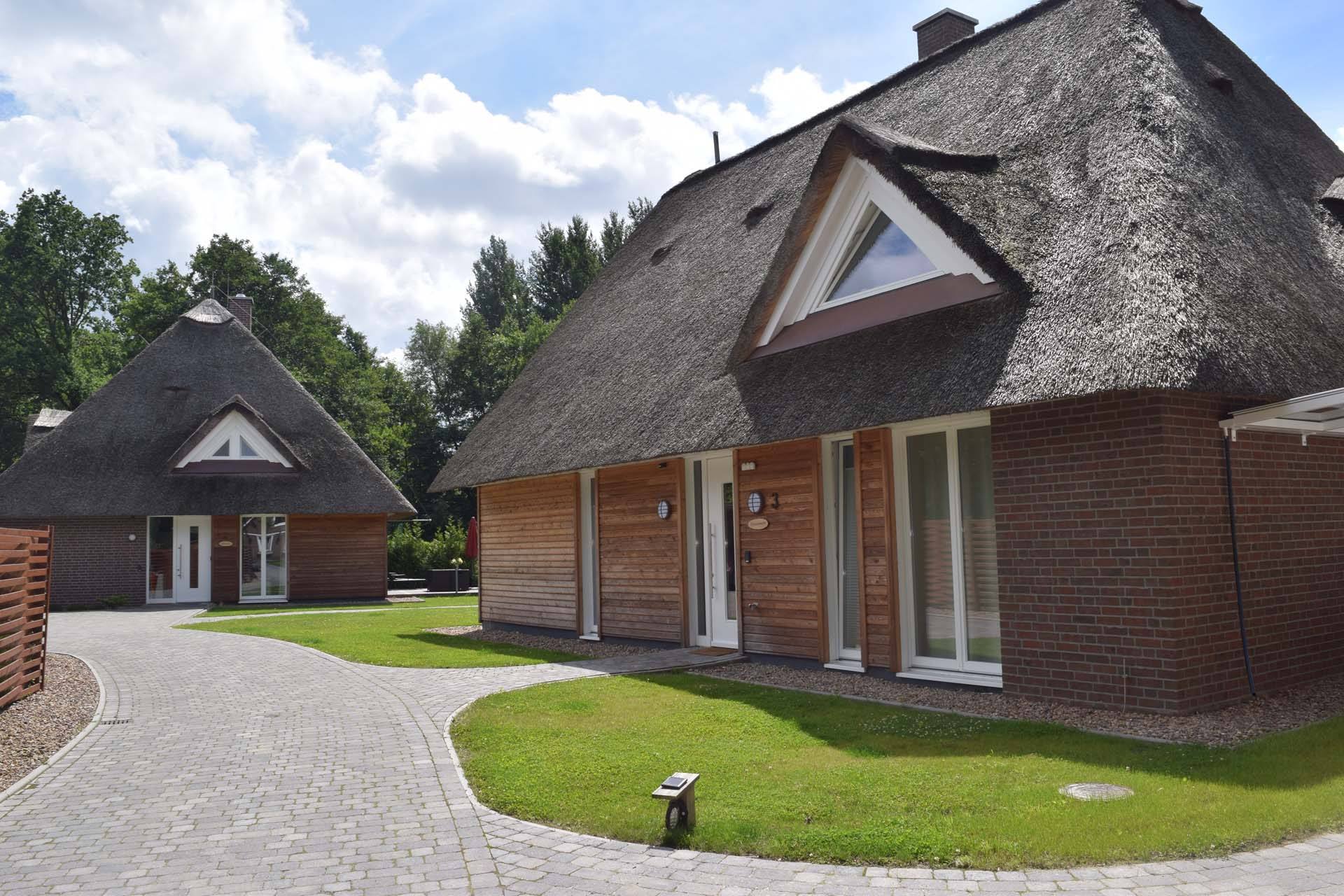 Einfahrt der Residenz am kleinen Meer mit reetgedeckten Häusern