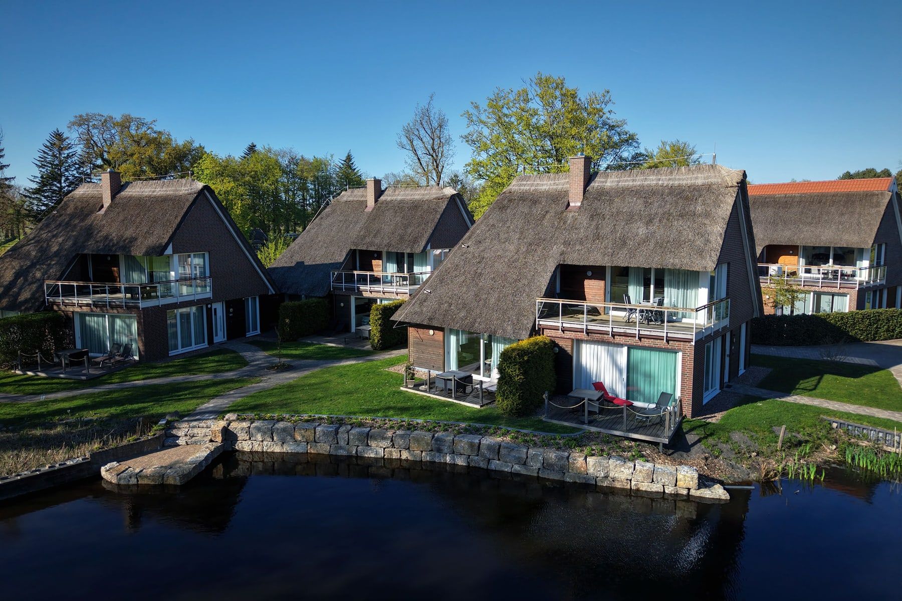 Luftbild: Häuser Wasser, Luft und Erde mit Balkonen zum See