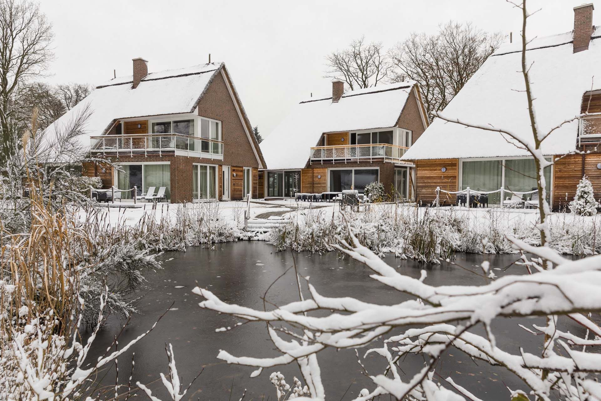Der zugefrorene See der Residenz im Winter mit Schnee auf den Reetdächern