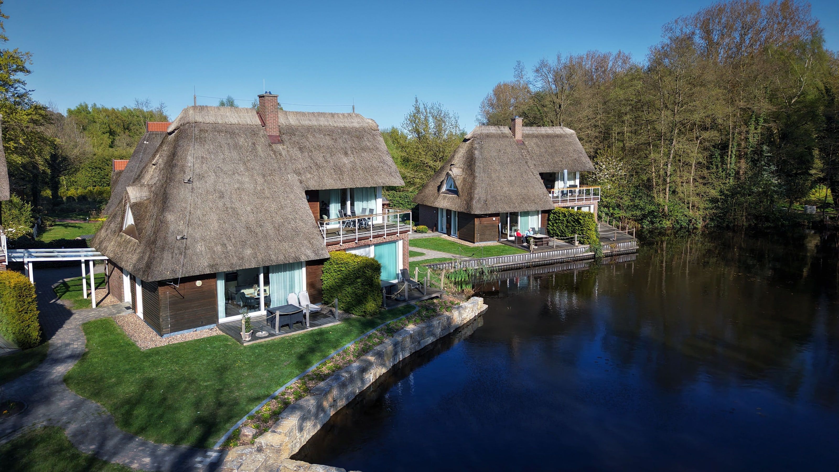 Luftaufnahme vom Ferienhaus Feuer mit Seeterrasse direkt am kleinen Meer, daneben Haus Löwenherz